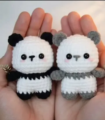 Two crochet panda keychains, one black and white, one grey and white, held in two palms